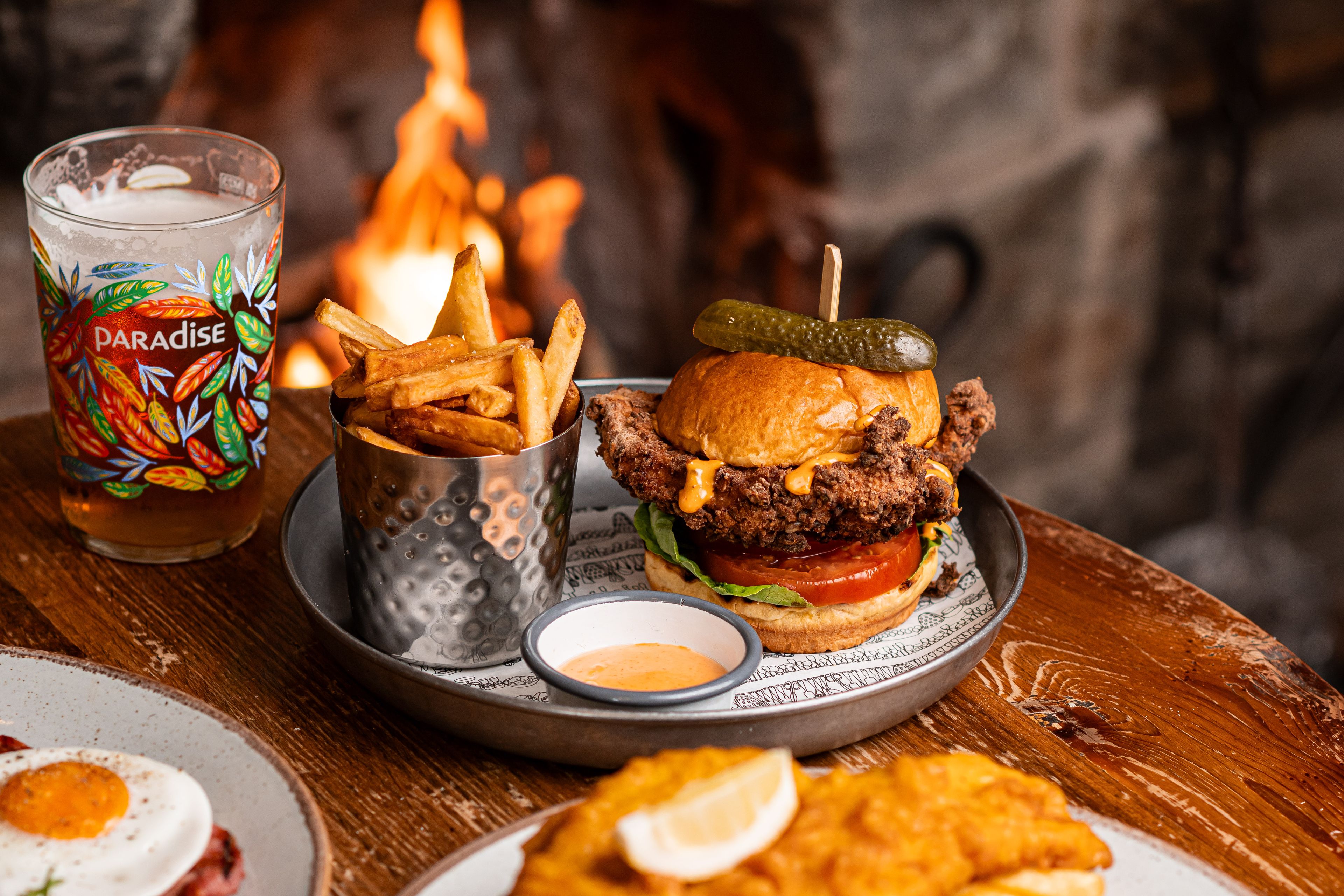 chicken burger and chips with a pint of thwaites ale by the fire